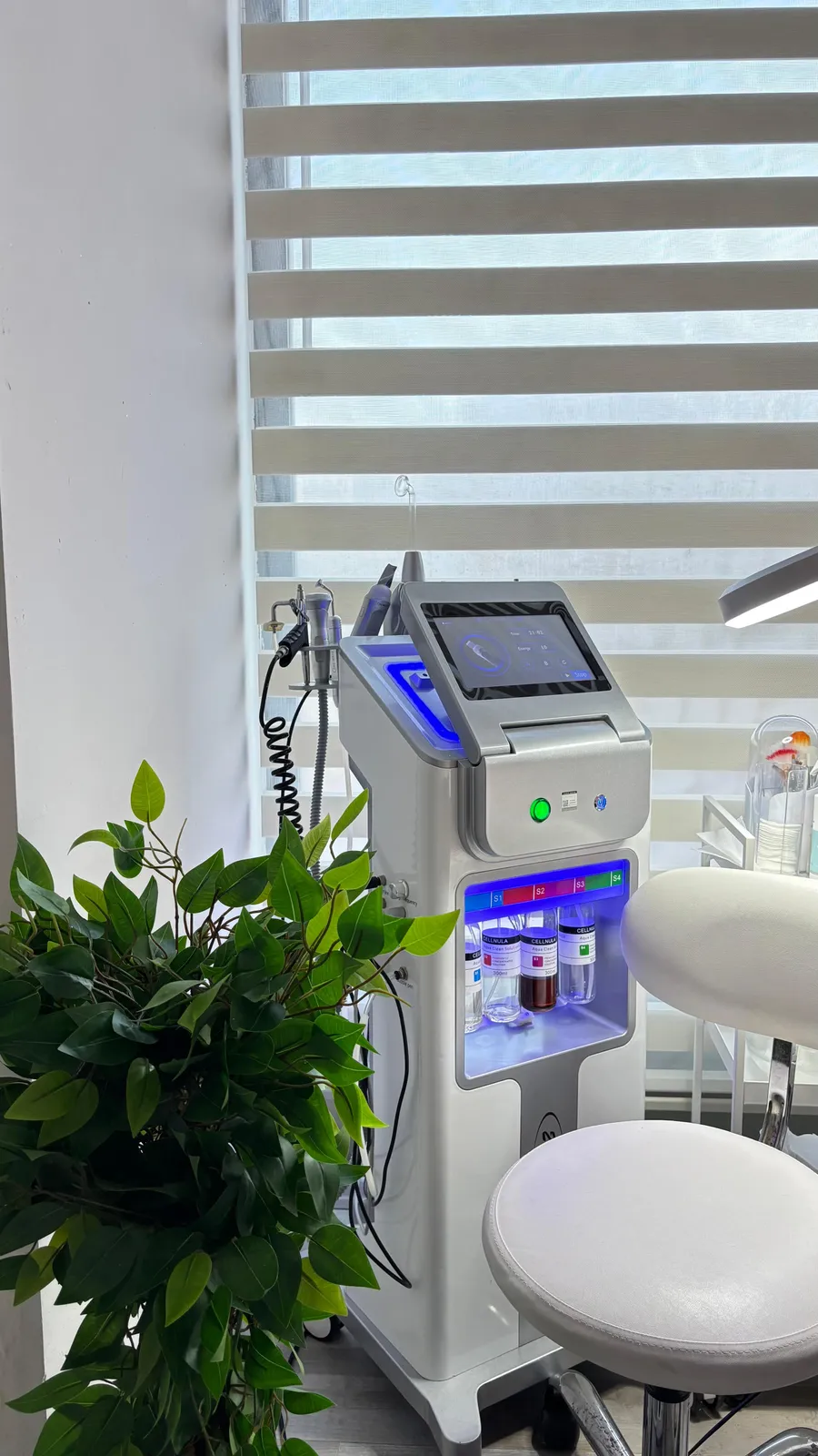 Bakım odasında duran Hydrafacial cihazı, başlığı ve serum şişeleri